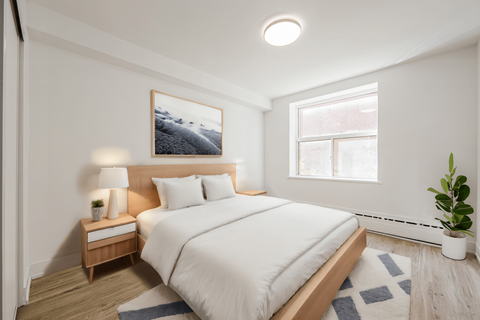 A bedroom with a bed, nightstand, and a painting on the wall. at 111 Cosburn, East York, ON